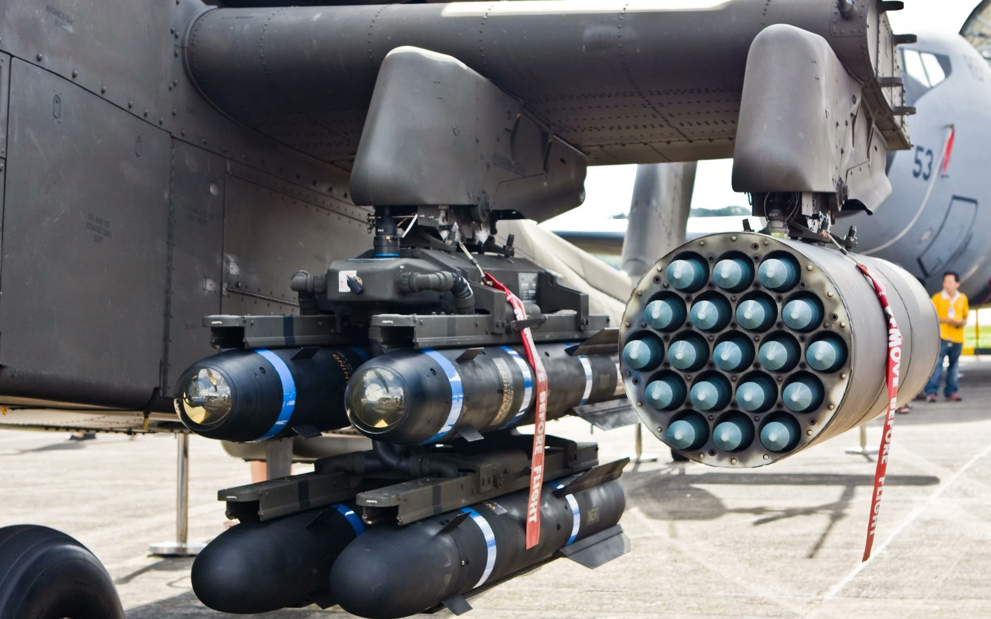 Hydra 70mm rocket pods and Hellfire missiles mounted under an AH-64 Apache helicopter's stub wing.